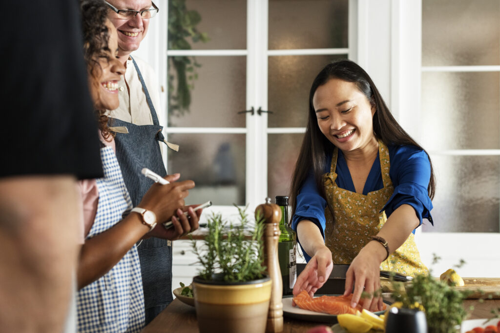 Chef demonstrating cooking techniques while participants take notes