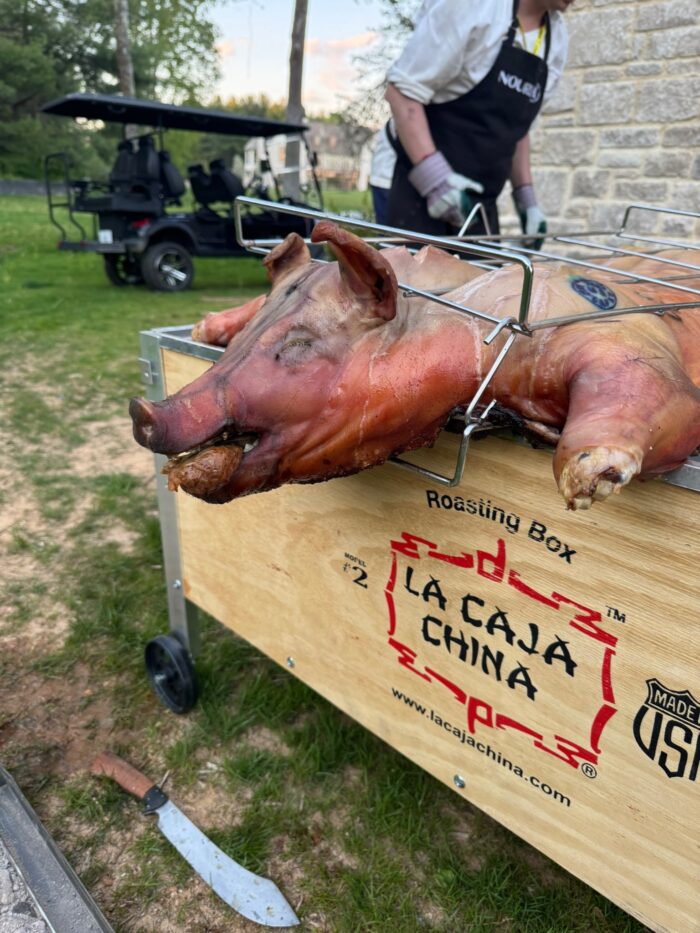Whole hog is roasted using La Caja China Box