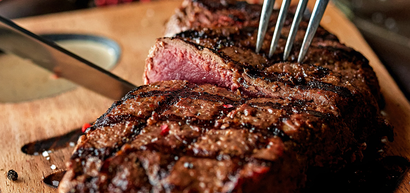 Close-up of a perfectly cooked steak being sliced, revealing a tender, juicy center.